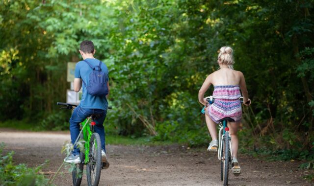 bicycle, riding on a path, bike in park, couple on bike, riding a bike, green bike, green path