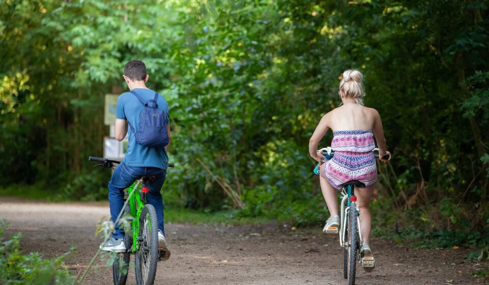 bicycle, riding on a path, bike in park, couple on bike, riding a bike, green bike, green path